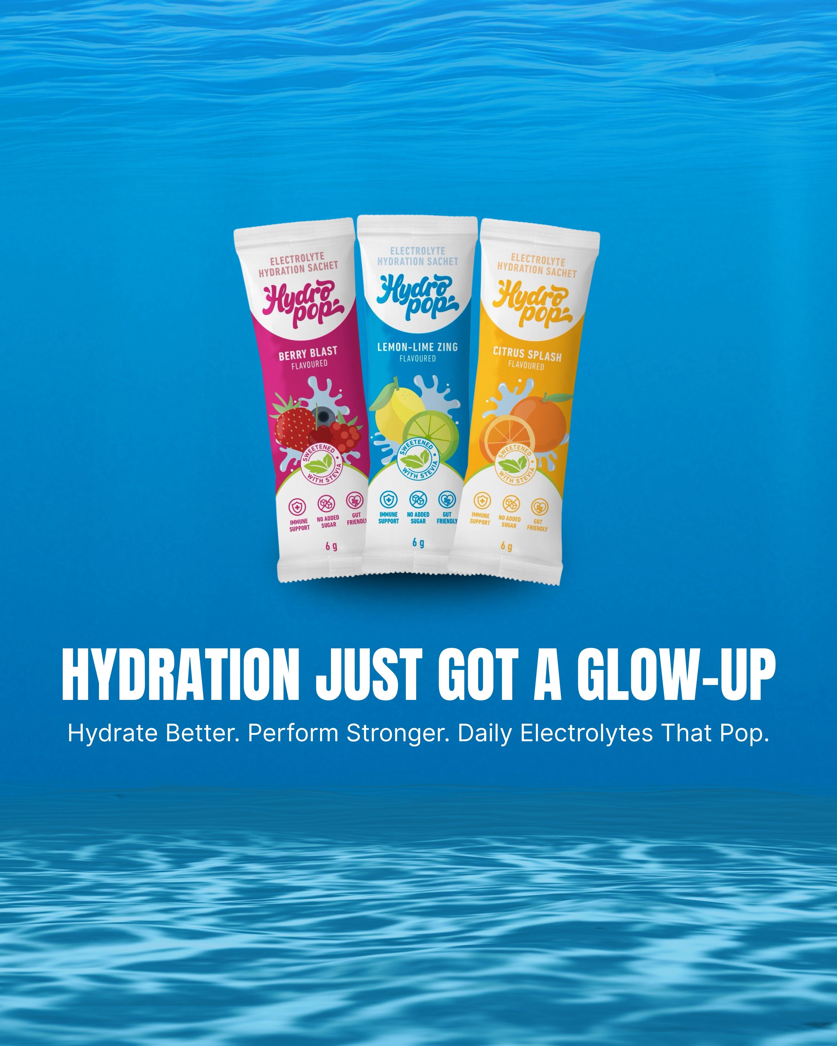 Three colorful packets of Hydropop Daily electrolytes on a blue underwater background with text: Hydrate Better. perform Stronger. Daily Electrolytes That Work.