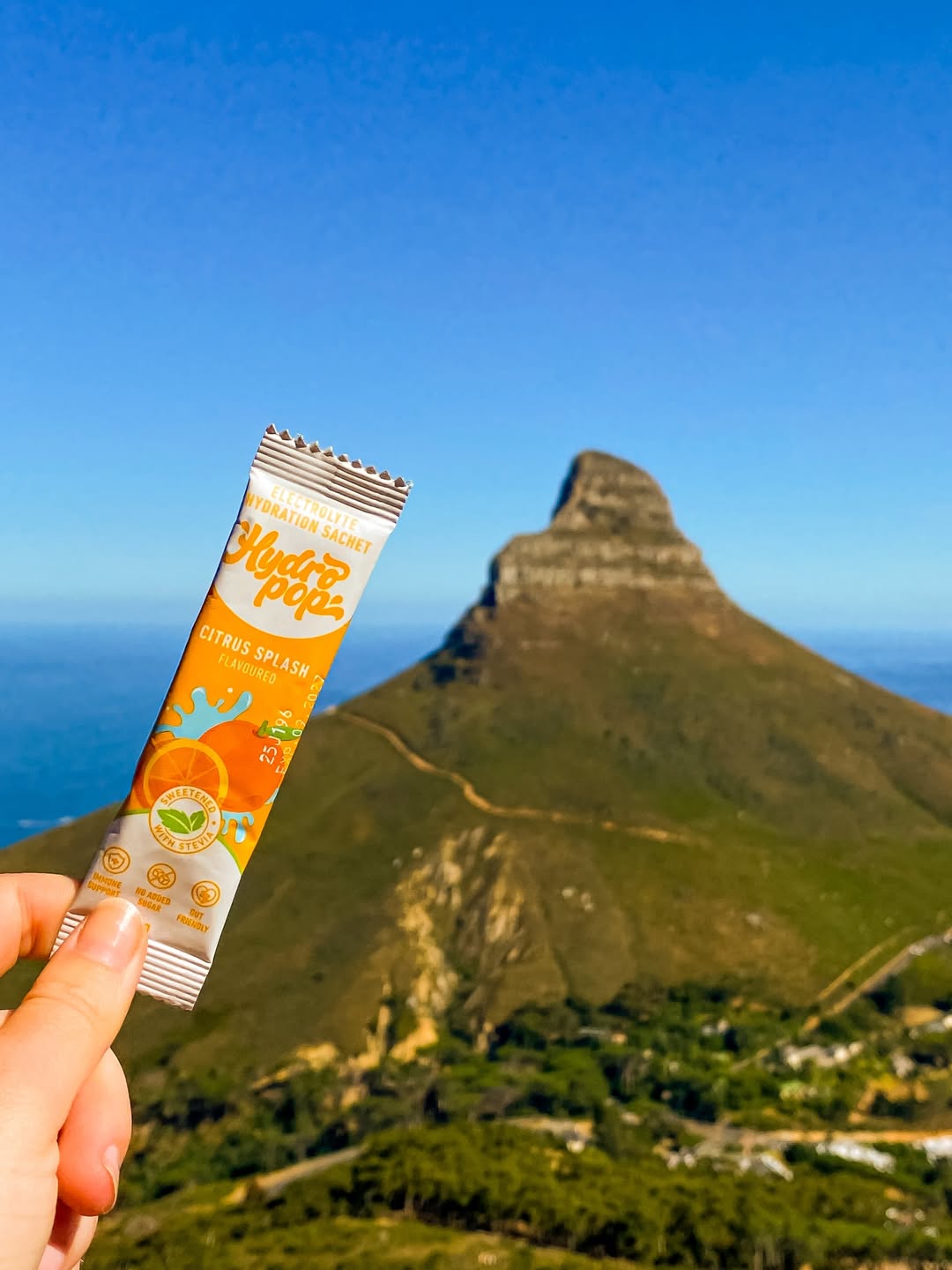 Hydropop Daily Electrolyte Citrus Splash Sachet with Lion's Head in the Background