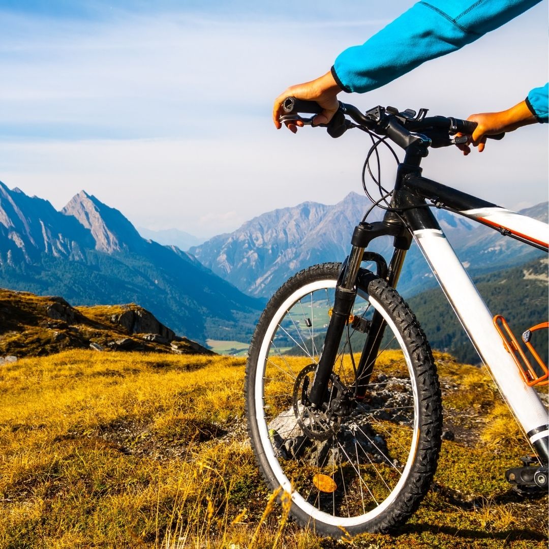 Person on a mountain bike with a scenic mountain landscape in the background